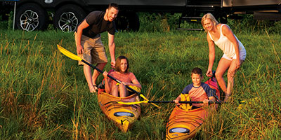 2023 KZ RV Sportsmen SE 281BHSE Travel Trailer at Lakefront Campsite with Kayaks