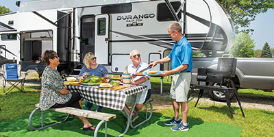 2023 KZ RV Durango Half Ton D256RKT Fifth Wheel Exterior Lifestyle Couples Cookout 2