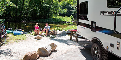 2023 KZ RV Escape E18 HATCH Travel Trailer with Couple Sitting at Campsite