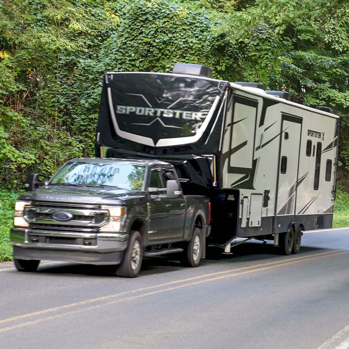 2026 KZ RV Sportster X 3411X Fifth Wheel Toy Hauler Being Towed to Campsite