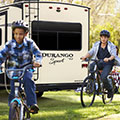 2018 KZ RV Durango 1500 Sport D270RLD Fifth Wheel Exterior with Kids Riding Bikes Outdoors